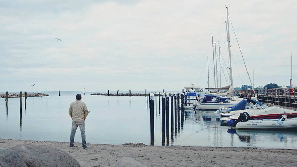 Mann blick vom Yachthafen aufs Meer