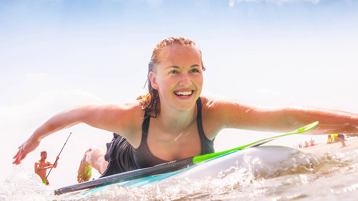 Surferin paddelt auf dem Wasser