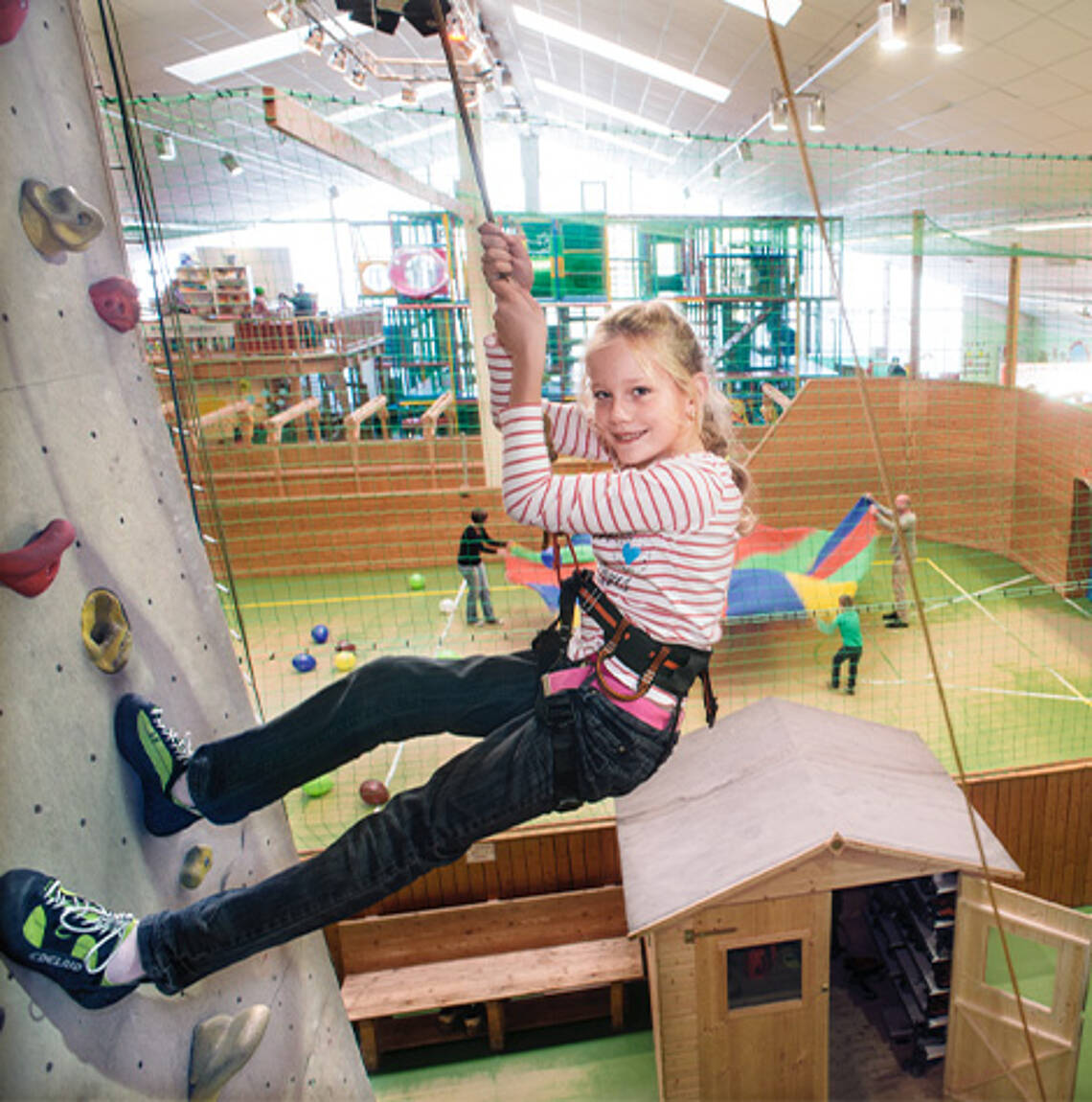Klettern im Funhalla Ein Mädchen hängt an der Kletterwand