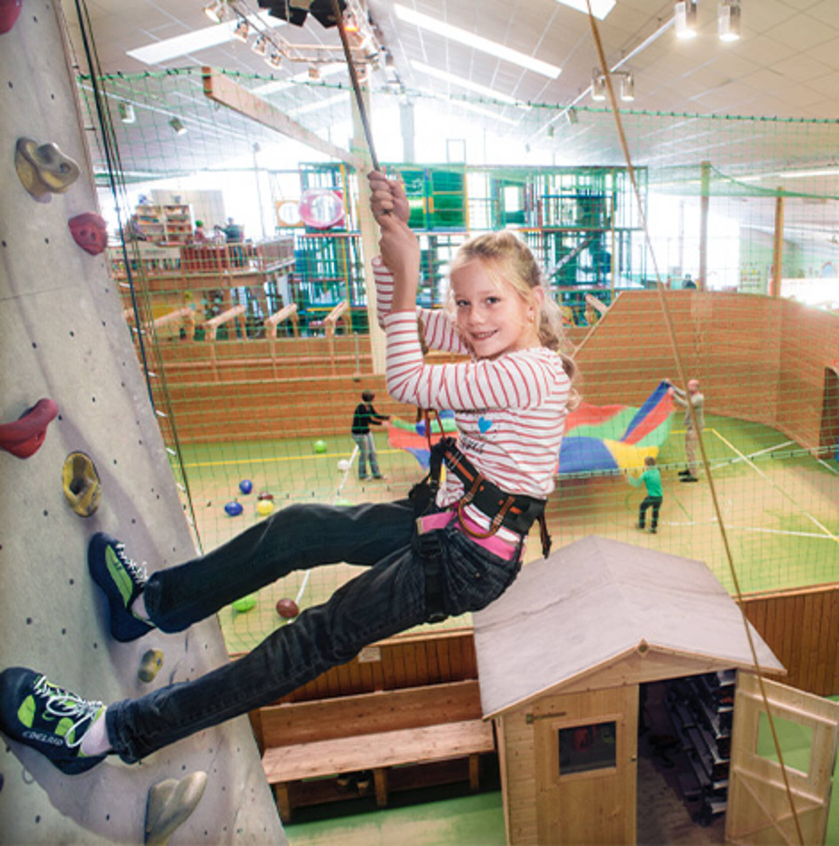 Klettern im Funhalla Ein Mädchen hängt an der Kletterwand