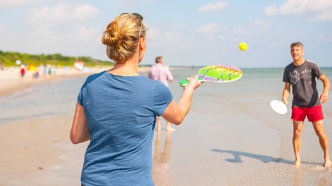 Ein Paar spielt Beachball am Wasser