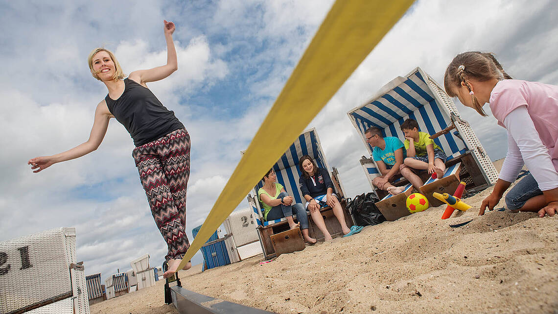 Ein Junge balanciert über eine Slackline