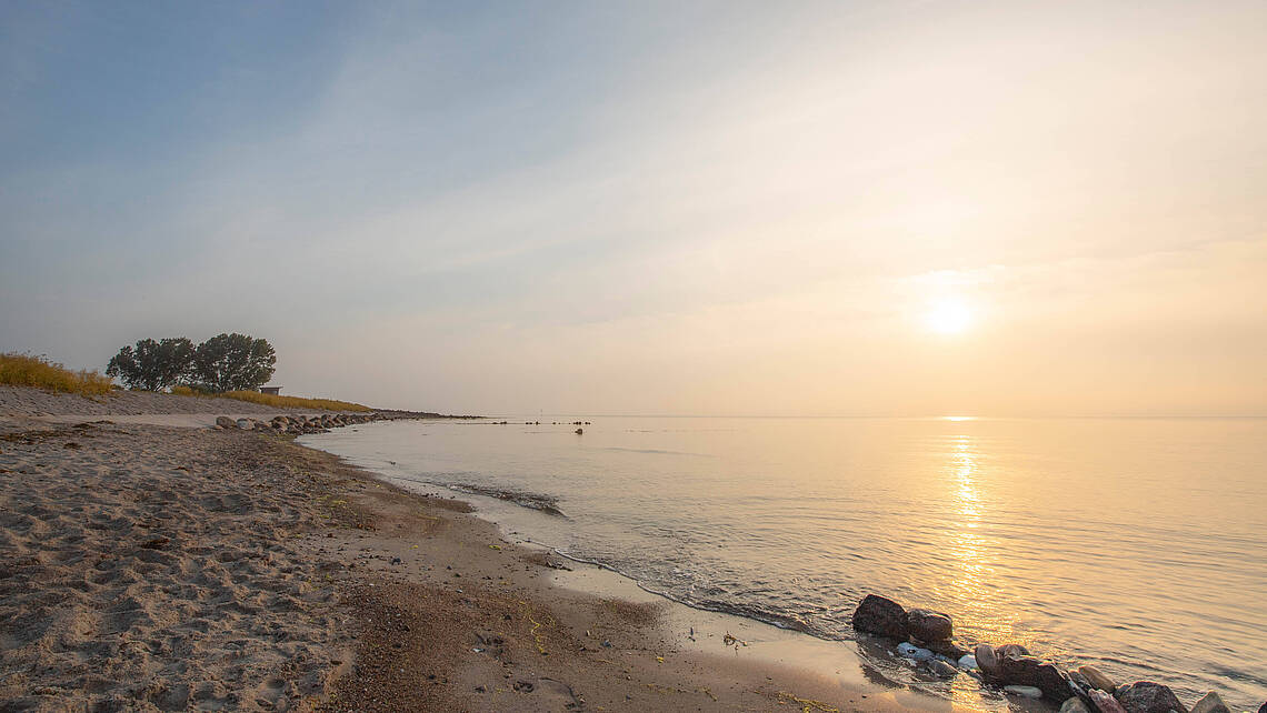 Strandabschnitt mit Sonnernuntergang am Horizont