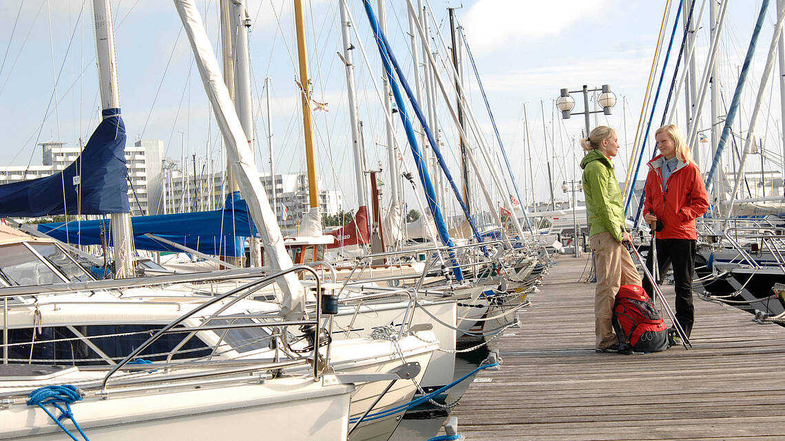 Zwei Menschen stehen an den Booten im Yachthafen