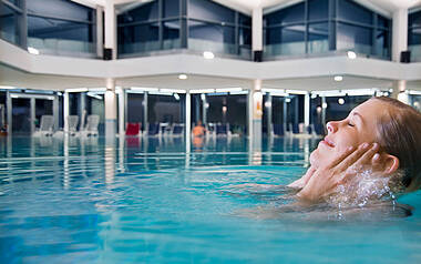 Frau schwimmt im Meerwasserschwimmbad