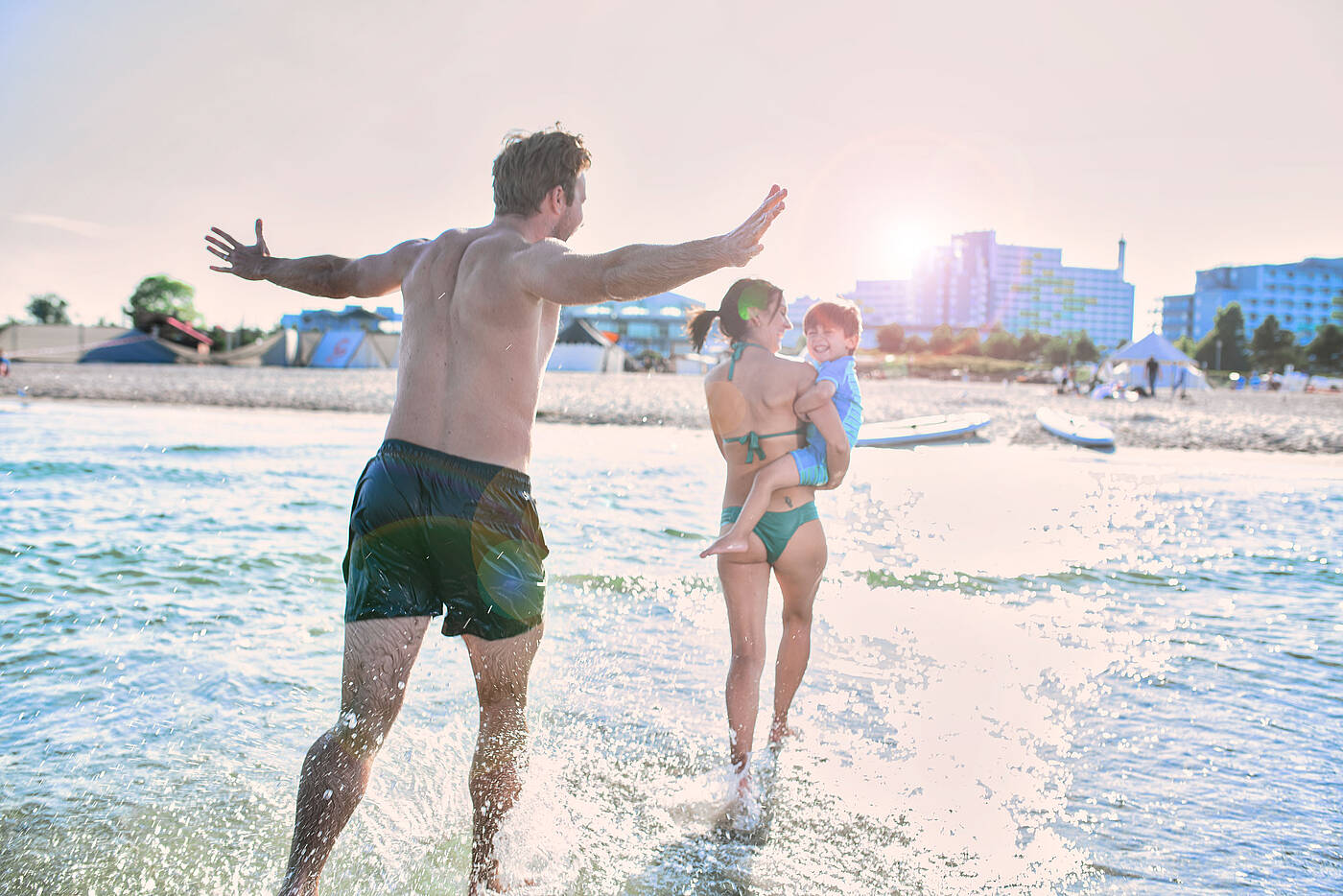 Strandurlaub im Ostsee Resort Dampland Eltern und Kind waten durchs flache Wasser