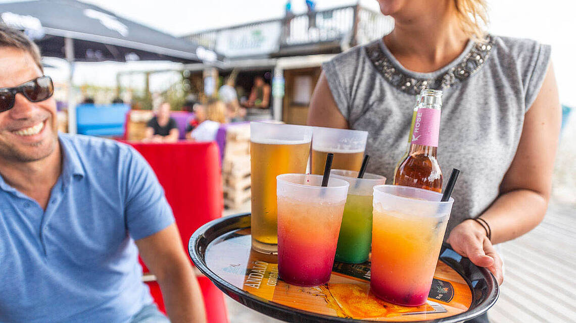 Kellnerin bringt Cocktails auf einem Tablett