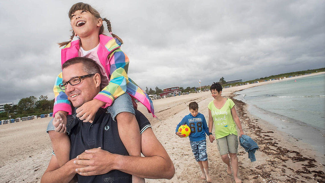 Eine Familie wandert gemeinsam am Strand entlang