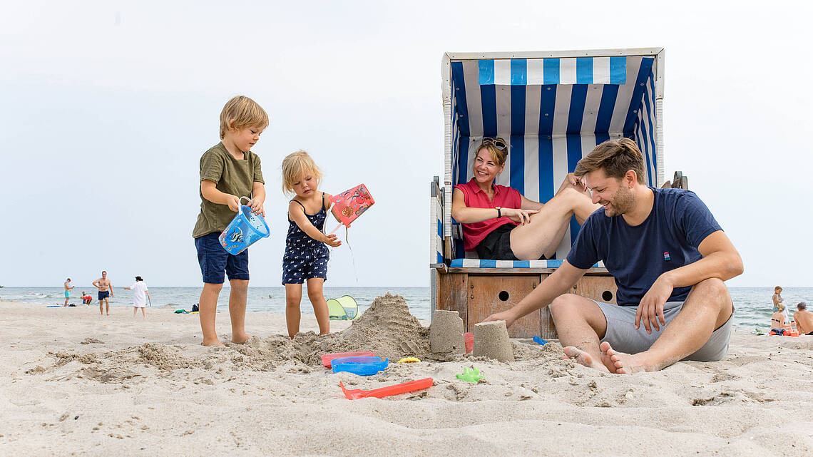 Familie sitzt am Strand