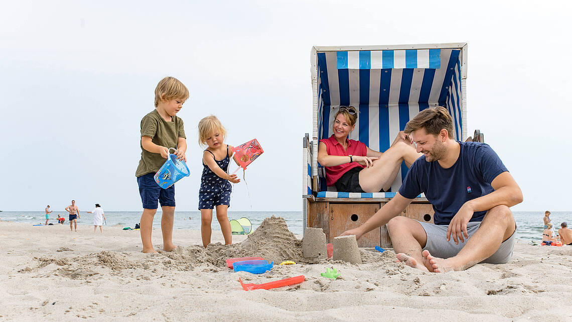 Familie sitzt am Strand