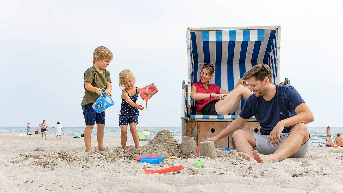 Familie sitzt am Strand