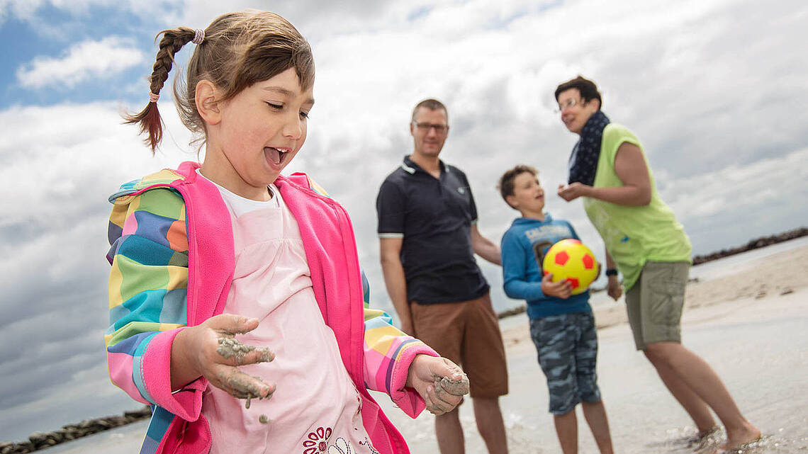 Eine Familie steht am Strand