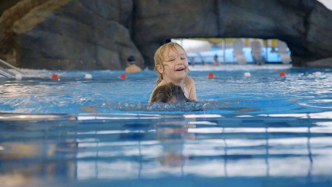 Ein kleines Mädchen schwimmt im Pool des Entdeckerbads