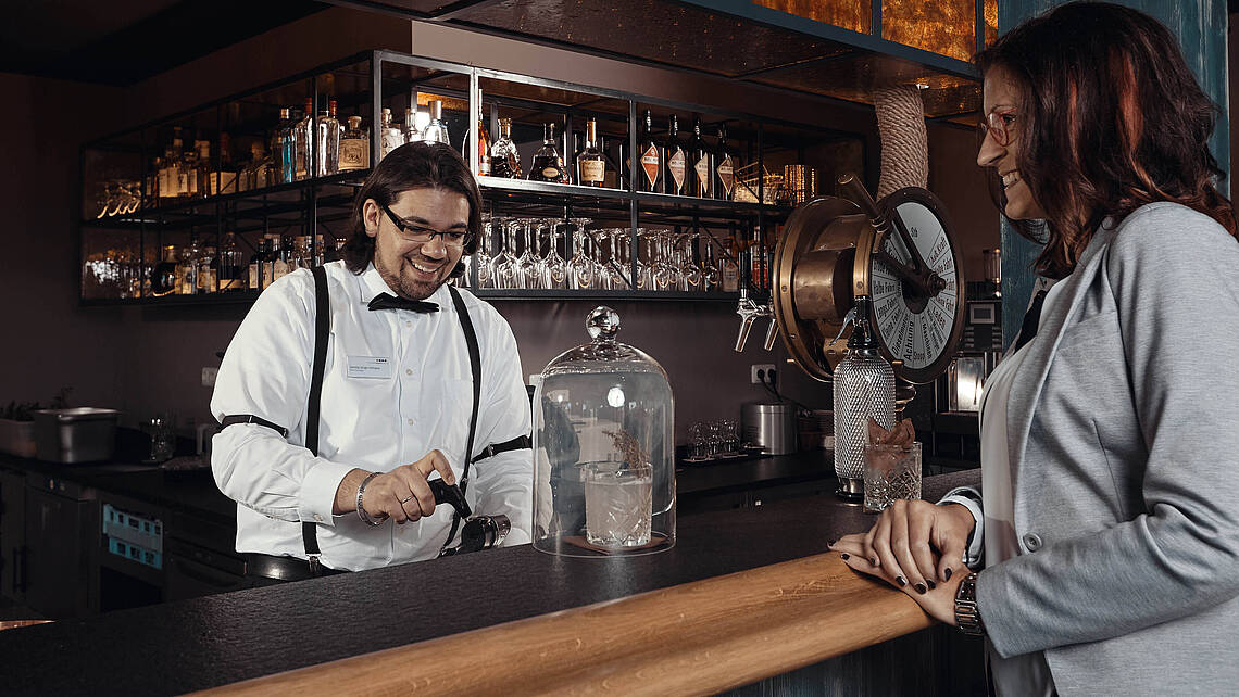 Barkeeper mixt einem Gast einen Cocktail