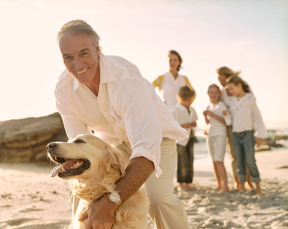 Hund im Ostsee Resort Dampland Älterer Mann umarmt seinen und am Strand