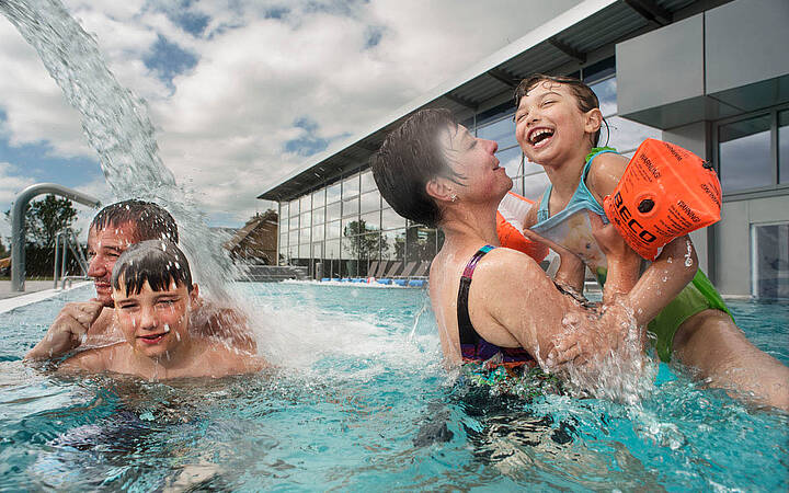 Familienspaß im Entdeckerbad Eltern und Kinder planschen im Aussenpool des Entdeckerbads